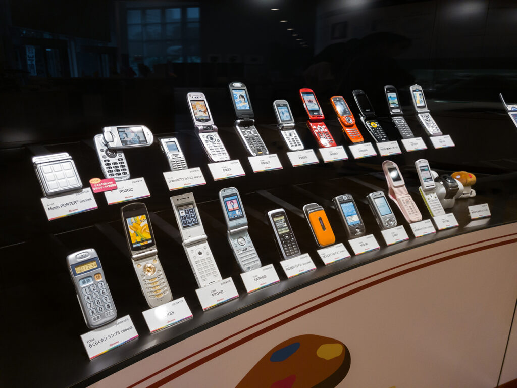 Tokyo, Japan - 07.2022: Vintage mobile phone and telephone being displayed at NTT Docomo History Square featuring old technology like FOMA and ISDN used in early Japanese telecommunication era